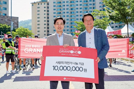 롯데카드는 지난 1일 강원도 원주시에서 열린 '2018 롯데카드 그란폰도 인 오크밸리' 대회에서 자전거 나눔 기금 1000만원을 원주시에 기부했다. 김창권 롯데카드 사장(왼쪽)과 원창묵 원주시장이 기념촬영을 하고 있다. 롯데카드 제공